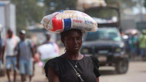 A woman carries a bag of pasta during a market day, which generates an intense border crossing ... A woman carries a bag of pasta during a market day, which generates an intense border crossing ...