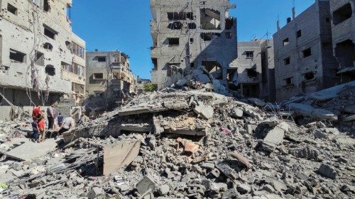 Palestinians gather at the site of Israeli strikes on houses and residential buildings, amid the ... Palestinians gather at the site of Israeli strikes on houses and residential buildings, amid the ...