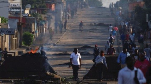 Locals walk past barricades that were used by protesters after the ruling Frelimo party was declared ...