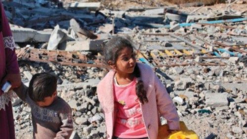 A displaced Palestinian woman stands with her children next to the rubble of destroyed buildings on ... A displaced Palestinian woman stands with her children next to the rubble of destroyed buildings on ...