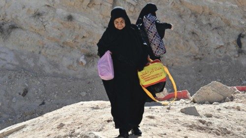 epa11687086 People carrying belongings walk at Masnaa border crossing, which was damaged by an ...
