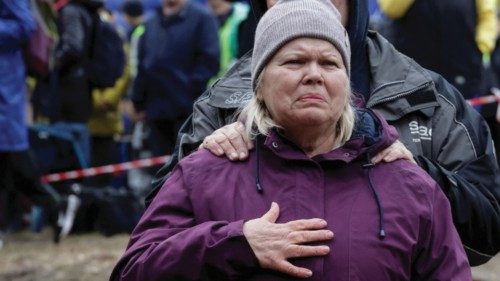 Residents react in front of their apartment building which was hit by a Russian air strike in ...