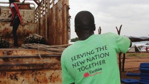 Caritas volunteer load tent poles in a transit camp for people returning to South Sudan from Sudan. ...