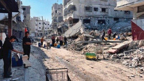 TOPSHOT - Palestinians fill containers with clean water in the midst of the devastation in Beit ... TOPSHOT - Palestinians fill containers with clean water in the midst of the devastation in Beit ...
