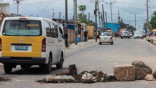 A vehicle drives past stones placed in the road as a barricade in the Maxaquene neighborhood of ... A vehicle drives past stones placed in the road as a barricade in the Maxaquene neighborhood of ...