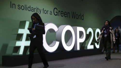Participants walk past an installation at the United Nations climate change conference COP29 in ... Participants walk past an installation at the United Nations climate change conference COP29 in ...