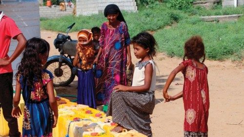 Internally displaced children queue to collect water from a truck at a camp in Al Hajjah on November ...