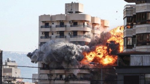 Smoke and flames rise after an Israeli strike on a building as people watch, in the Chiyah district ... Smoke and flames rise after an Israeli strike on a building as people watch, in the Chiyah district ...