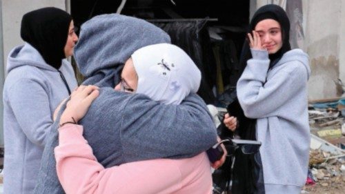 TOPSHOT - Women greet each other as displaced people make their way back to their homes in the south ... TOPSHOT - Women greet each other as displaced people make their way back to their homes in the south ...