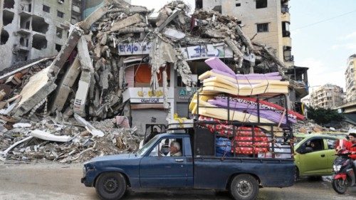 epa11747416 People drive by a damaged building as displaced residents return following a ceasefire ...