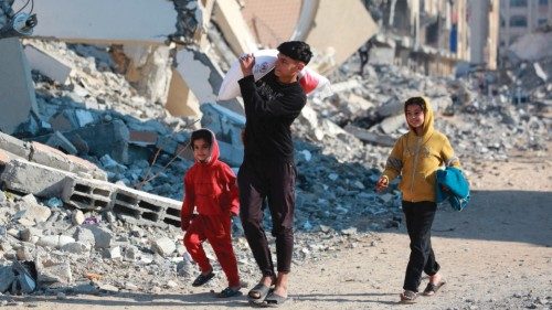 TOPSHOT - A Palestinian boy carries a bag of flour he received from an aid distribution center in ... TOPSHOT - A Palestinian boy carries a bag of flour he received from an aid distribution center in ...