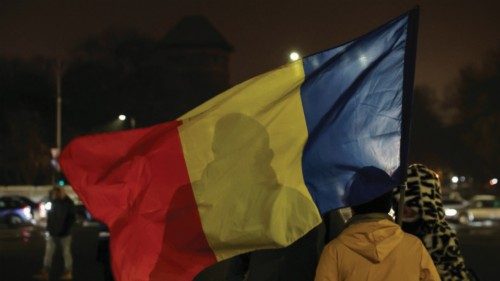 A woman holds a Romanian flag at Victory Square, after the annulment of the presidential election ...
