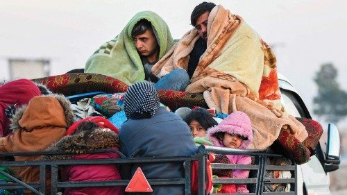 Displaced Syrian Kurds ride vehicles loaded with belongings on the Aleppo-Raqqa highway as they flee ...