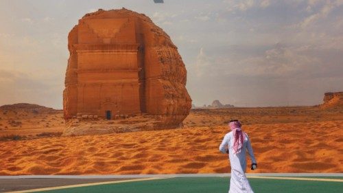 A delegate walks plast a poster of a Saudi archaeological site outside the conference centre where ... A delegate walks plast a poster of a Saudi archaeological site outside the conference centre where ...