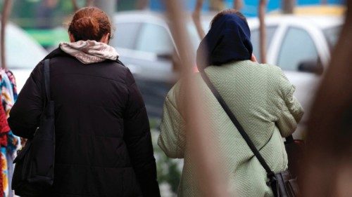 An Iranian woman, not wearing the mandatory hijab, walks next to a woman wearing the hijab in a ... An Iranian woman, not wearing the mandatory hijab, walks next to a woman wearing the hijab in a ...