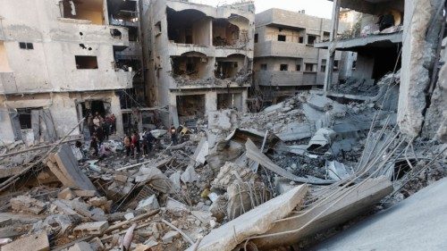 Palestinians inspect the damage at the site of an Israeli strike, amid the Israel-Hamas conflict, at ...