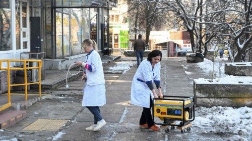 Employees move a generator supplying a pharmacy with electricity during a power outage in the ... Employees move a generator supplying a pharmacy with electricity during a power outage in the ...