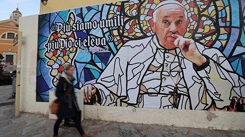 A woman walks in front of a fresco representing Pope Francis close to Ajaccio's Cathedral, in ... A woman walks in front of a fresco representing Pope Francis close to Ajaccio's Cathedral, in ...