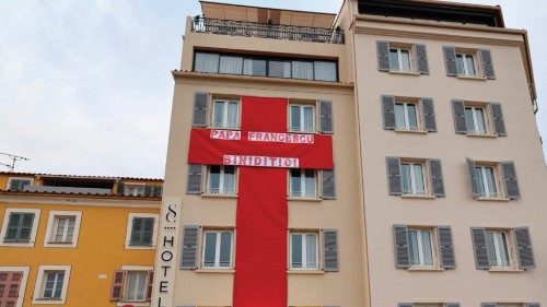 A man adjusts a light on a red cross hung outside a hotel in Ajaccio, Corsica, on December 12, 2024, ... A man adjusts a light on a red cross hung outside a hotel in Ajaccio, Corsica, on December 12, 2024, ...