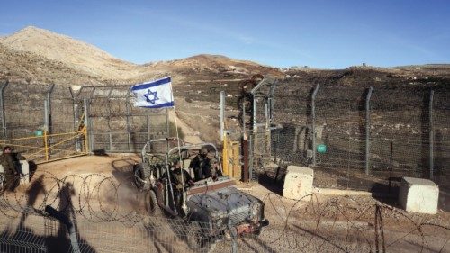 An Israeli military vehicle rides by the ceasefire line between the Israeli-occupied Golan Heights ...