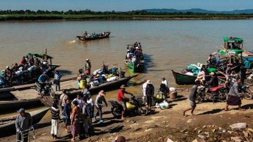 This photo taken on December 6, 2024 shows people from Bahmo crossing a river as they arrive at ... This photo taken on December 6, 2024 shows people from Bahmo crossing a river as they arrive at ...