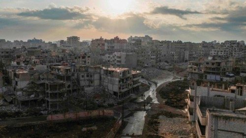 This aerial picture shows people walking past destroyed buildings in the centre of Homs on December ... This aerial picture shows people walking past destroyed buildings in the centre of Homs on December ...