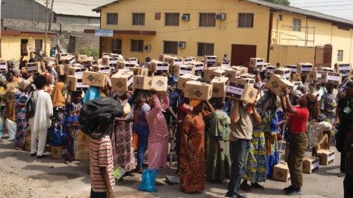 epa11788614 Local recipients receive boxes of food at the Lagos Food Bank for the city's poorest, in ...