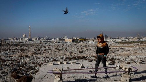 epaselect epa11790833 A young boy walks on top of a building in the Yarmouk refugee camp on the ... epaselect epa11790833 A young boy walks on top of a building in the Yarmouk refugee camp on the ...