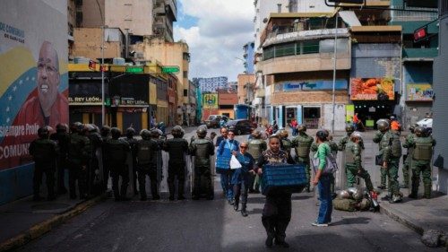 People walk past Bolivarian National Guard members near the Federal Legislative Palace during the ... People walk past Bolivarian National Guard members near the Federal Legislative Palace during the ...