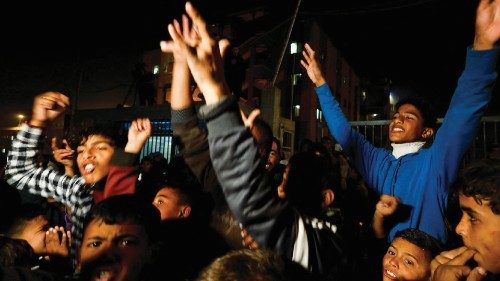 Palestinians react as they wait for news of a ceasefire deal with Israel, in Khan Younis in the ...