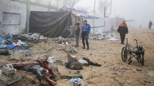 Palestinian boys stand near a damaged tent for displaced people, after an Israeli airstrike, amid ... Palestinian boys stand near a damaged tent for displaced people, after an Israeli airstrike, amid ...
