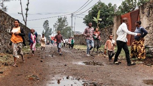 Residents run off after observing members of the M23 armed group walking through a street of the ... Residents run off after observing members of the M23 armed group walking through a street of the ...