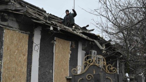 A man clears debris on a roof of a house damaged following a Russian airstrike in the town of ... A man clears debris on a roof of a house damaged following a Russian airstrike in the town of ...