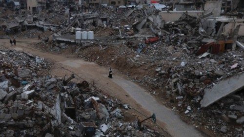 Palestinians walk among the rubble of buildings destroyed during the Israeli offensive, amid a ... Palestinians walk among the rubble of buildings destroyed during the Israeli offensive, amid a ...