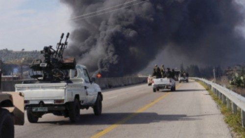 Smoke rises while members of the Syrian forces ride on a vehicle as they battle against a nascent ... Smoke rises while members of the Syrian forces ride on a vehicle as they battle against a nascent ...