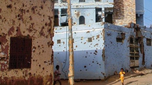 TOPSHOT - Sudanese children walk next to bullet-riddled buildings in Khartoum's twin-city Omdurman ...
