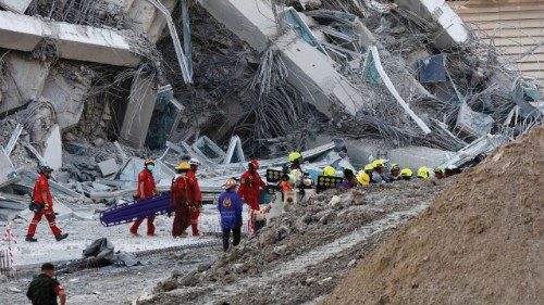 Rescue personnel work near a building that collapsed after a strong earthquake struck central ... Rescue personnel work near a building that collapsed after a strong earthquake struck central ...