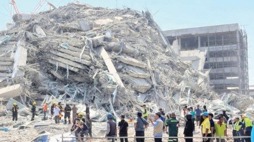 People stand near a collapsed building after a strong earthquake struck central Myanmar on Friday, ... People stand near a collapsed building after a strong earthquake struck central Myanmar on Friday, ...