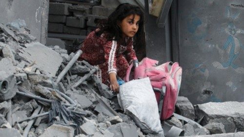 A girl holds a bag as Palestinians inspect the site of an Israeli strike on a house, in Khan Younis ... A girl holds a bag as Palestinians inspect the site of an Israeli strike on a house, in Khan Younis ...