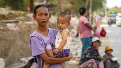 A mother holds up her child as she stands on a roadside waiting for a donation of relief supplies ... A mother holds up her child as she stands on a roadside waiting for a donation of relief supplies ...