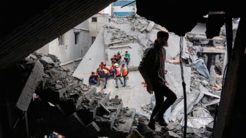 TOPSHOT - A man walks amids the rubble of a building as Palestinian rescuers work at the site of an ... TOPSHOT - A man walks amids the rubble of a building as Palestinian rescuers work at the site of an ...