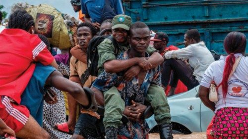 A resident carries a Congolese soldier as others wade through floodwaters in the Ndjili district of ... A resident carries a Congolese soldier as others wade through floodwaters in the Ndjili district of ...