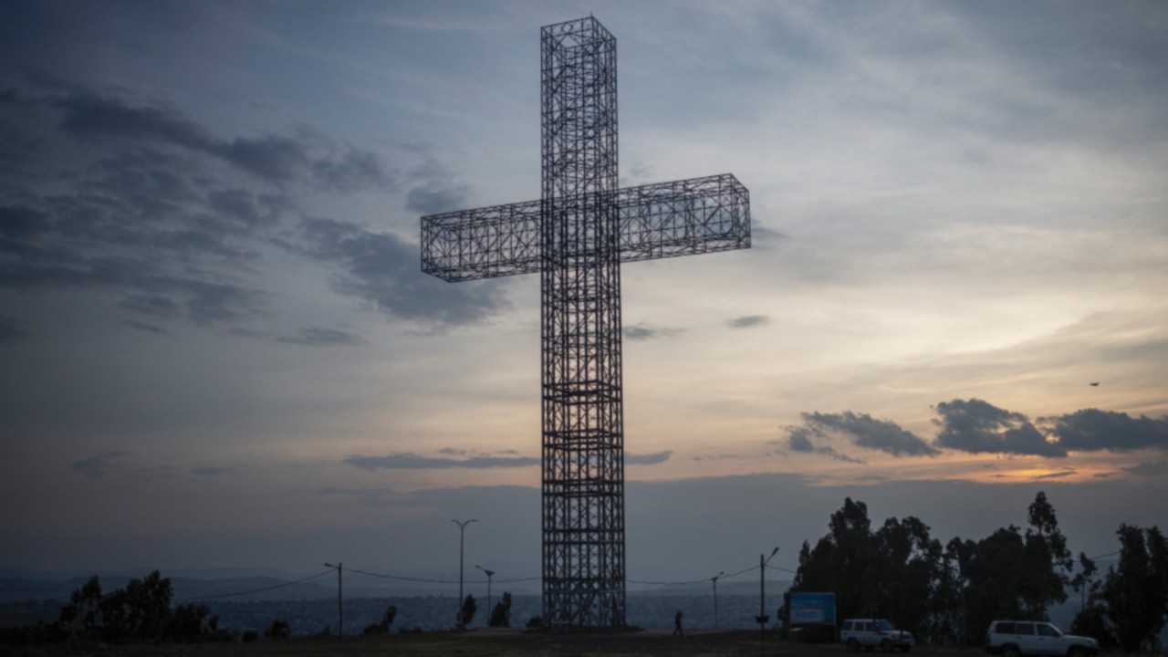 A person walks next to a 52 meters high giant steel cross overlooking the city of Mekele, Tigray ...