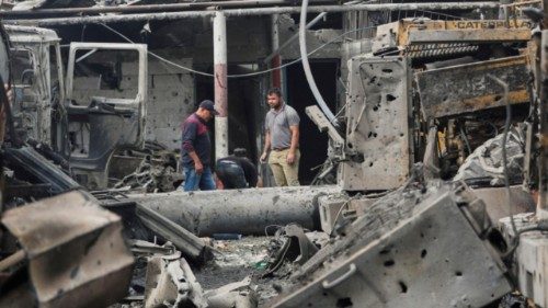 Palestinians inspect the site of an Israeli strike that hit machinery, in Jabalia refugee camp in ...
