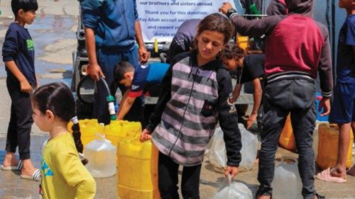 A Palestinian girl ferries water containers back from a distribution point at the Nuseirat refugee ... A Palestinian girl ferries water containers back from a distribution point at the Nuseirat refugee ...
