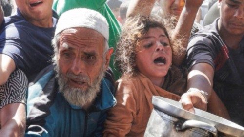 Palestinians gather as they wait to receive food cooked by a charity kitchen, in Khan Younis, ... Palestinians gather as they wait to receive food cooked by a charity kitchen, in Khan Younis, ...