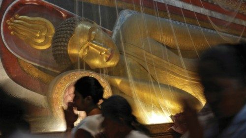Buddhist devotees worship while walking through the inside of a temple, where Buddha statues have ... Buddhist devotees worship while walking through the inside of a temple, where Buddha statues have ...