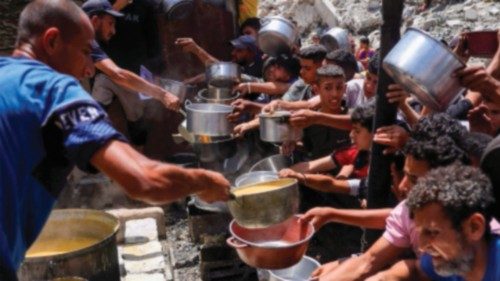 Displaced Palestinians gather to collect portions of cooked food at a charity distribution in ... Displaced Palestinians gather to collect portions of cooked food at a charity distribution in ...