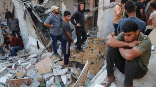 A man sits as Palestinians gather at the site of an Israeli strike on a house in Jabalia, in the ... A man sits as Palestinians gather at the site of an Israeli strike on a house in Jabalia, in the ...