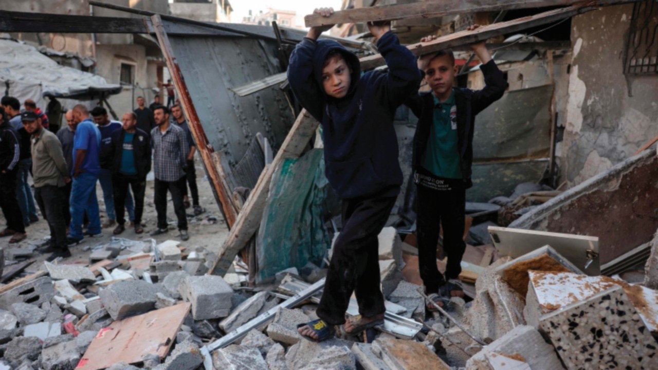 TOPSHOT - People check the destruction following an Israeli strike that hit the home of a ...